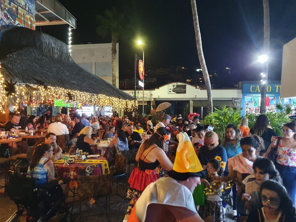 Customers handing out candy to costumed children along the tables at Cabo Cantina.