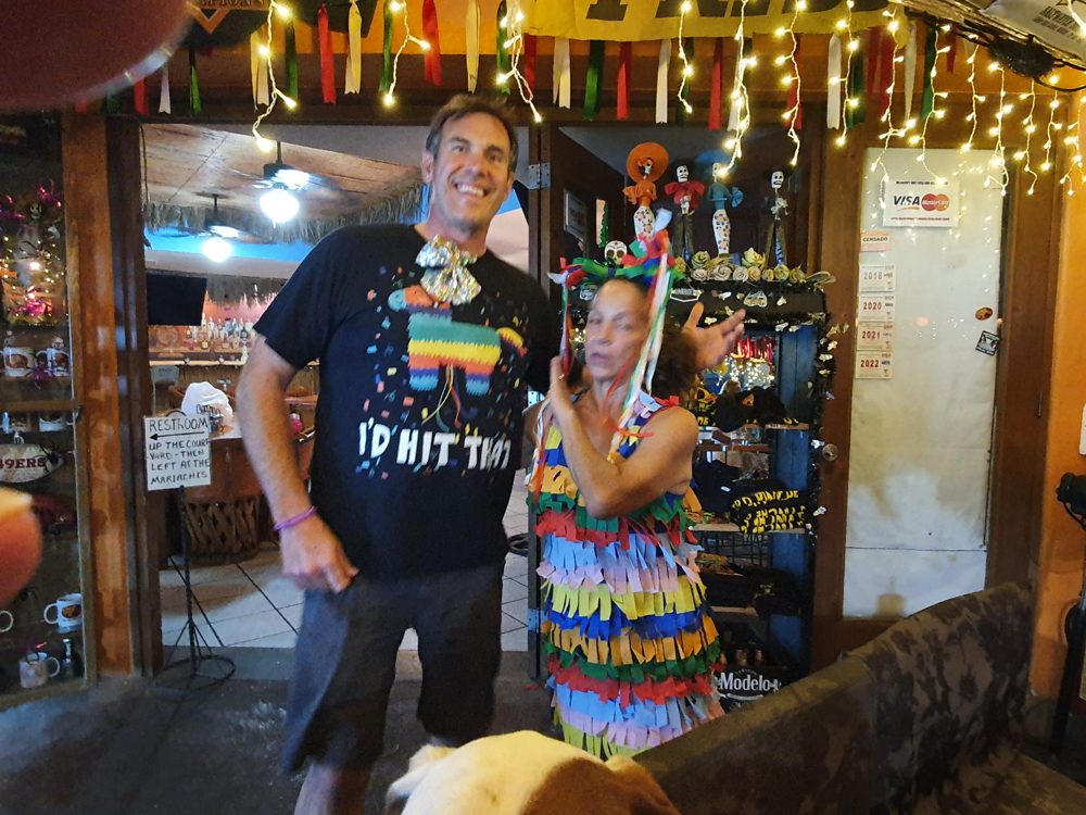 Two customers celebrating Halloween in coordinated candy and piñata-themed costumes.